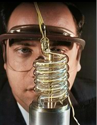 man in glasses watching a lightning bulb